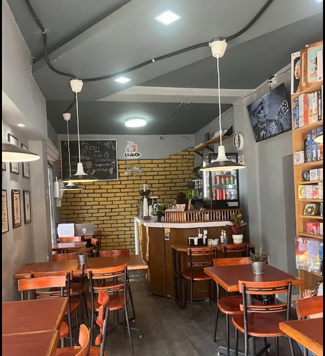 Interior de El Jugador con biblioteca y mesas